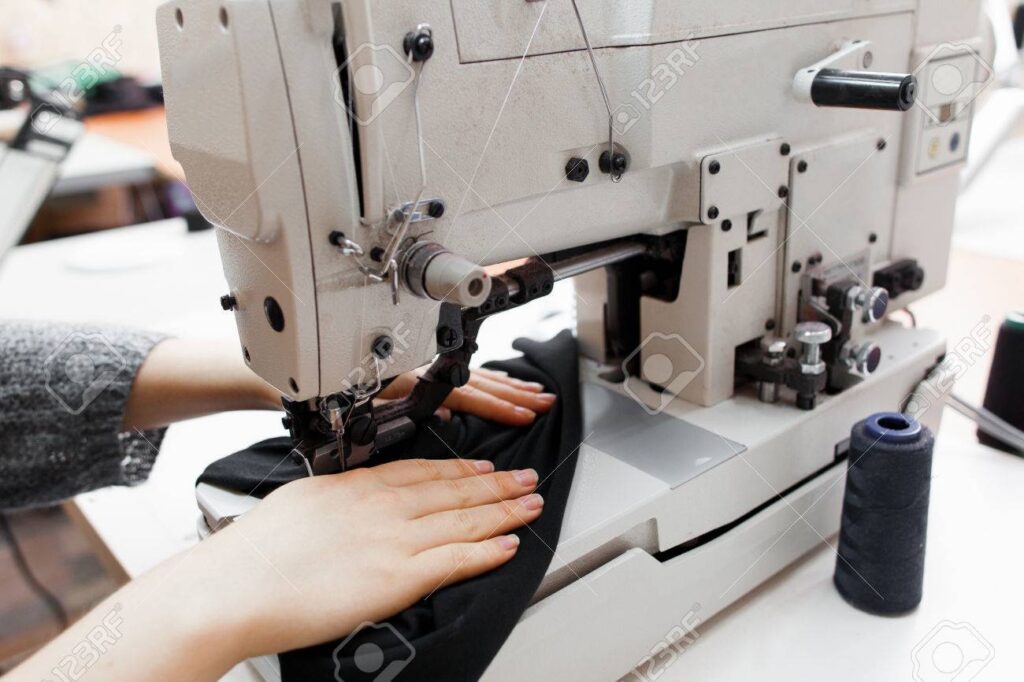 Woman stitching dark fabric on sewing machine
